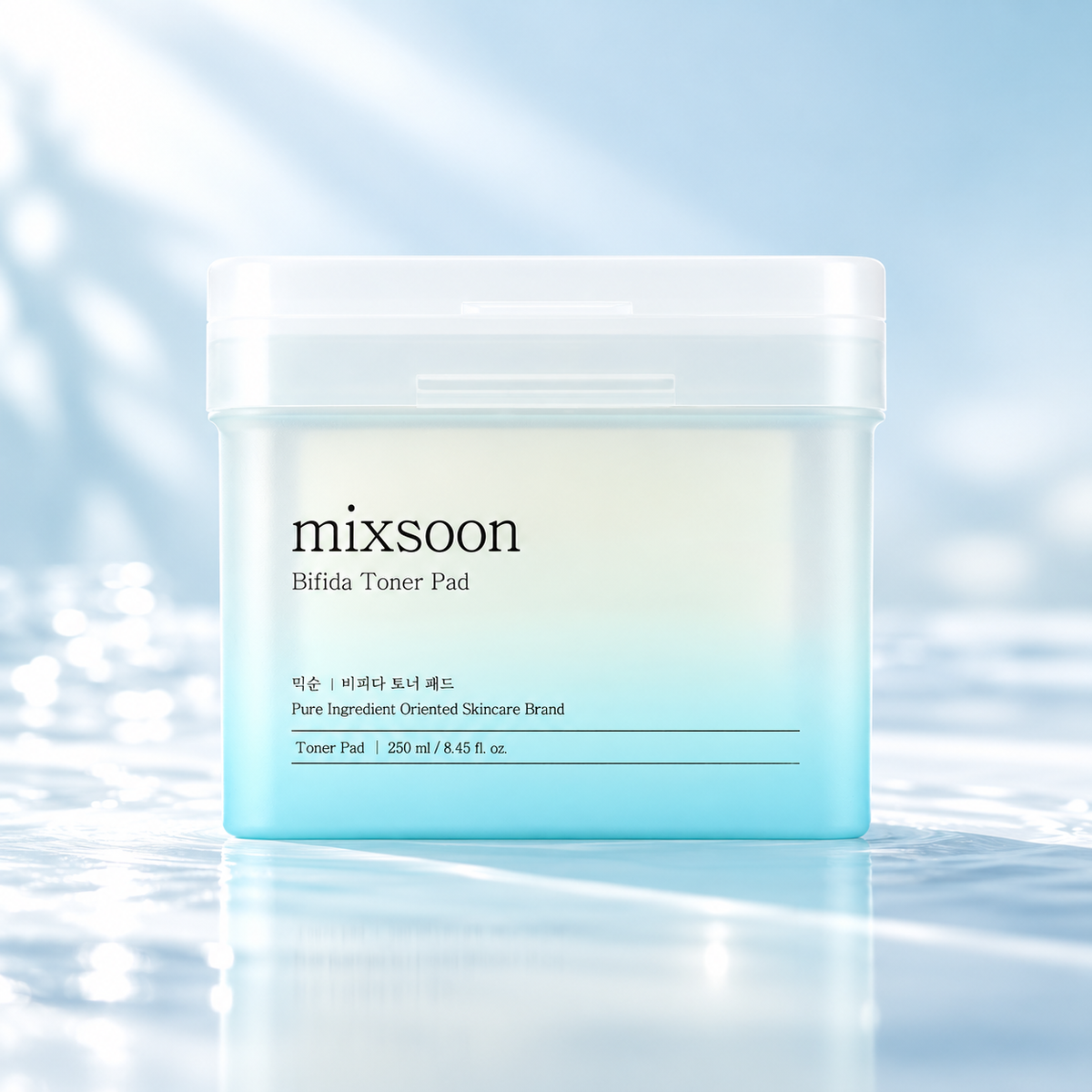 Mixsoon Bifida Toner Pad 250ml Korean skincare toner pads in a minimalist white and aqua-blue container, presented on a glossy water surface with delicate ripples and reflections. A refreshing K-beauty skincare composition featuring soft blue tones, natural daylight and a clean, luxurious aesthetic, highlighting hydration and skin barrier care.